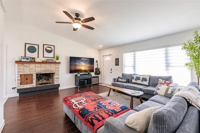 a living room with furniture a fireplace and a flat screen tv