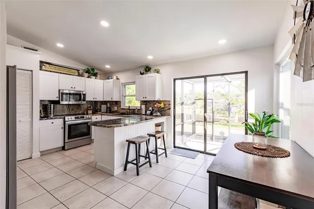 a kitchen with stainless steel appliances granite countertop a refrigerator and a stove top oven