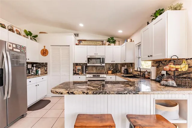 a kitchen with stainless steel appliances a refrigerator sink stove microwave and cabinets
