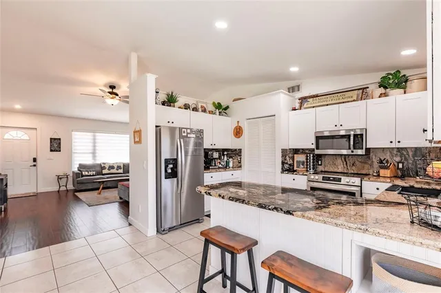 a kitchen with granite countertop a sink stainless steel appliances and cabinets