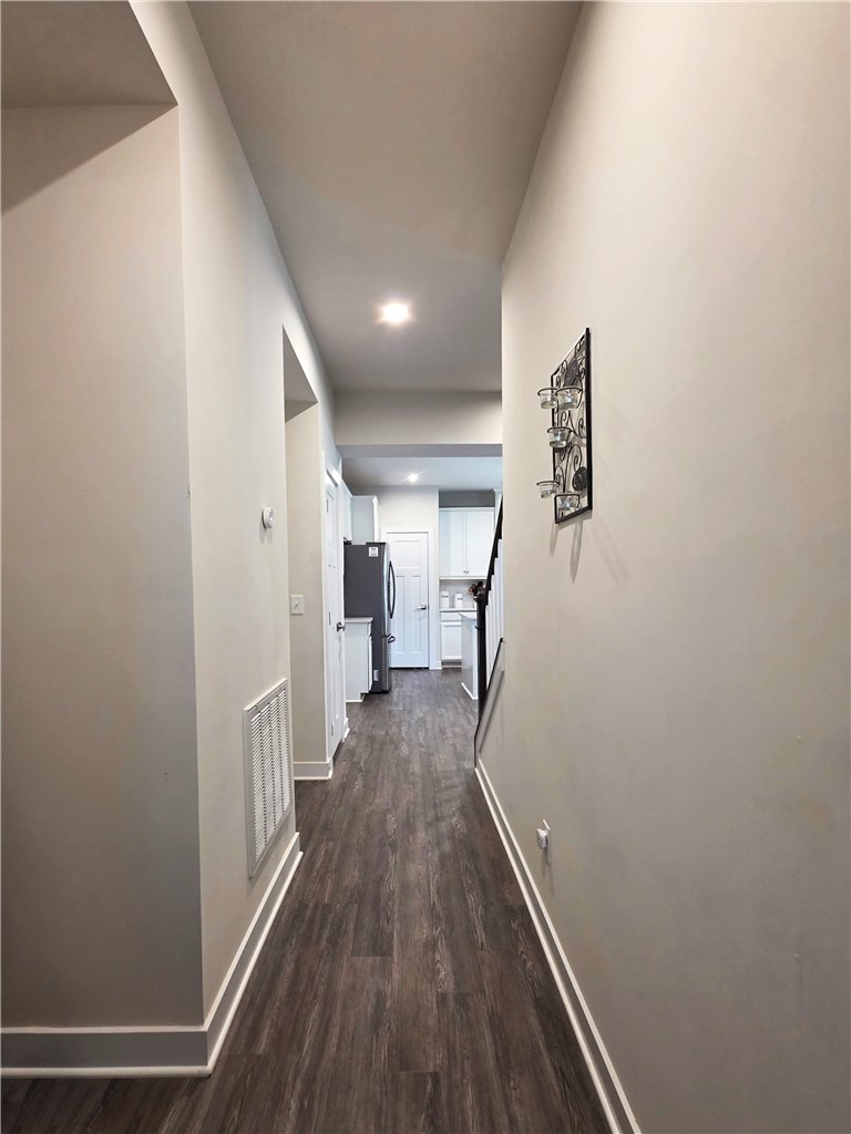 224 Bronson Ridge Anderson, SC 29621 - Photo 10 of 42 A well-lit hallway with rich wood flooring leads to the kitchen, offering a seamless flow within the home.