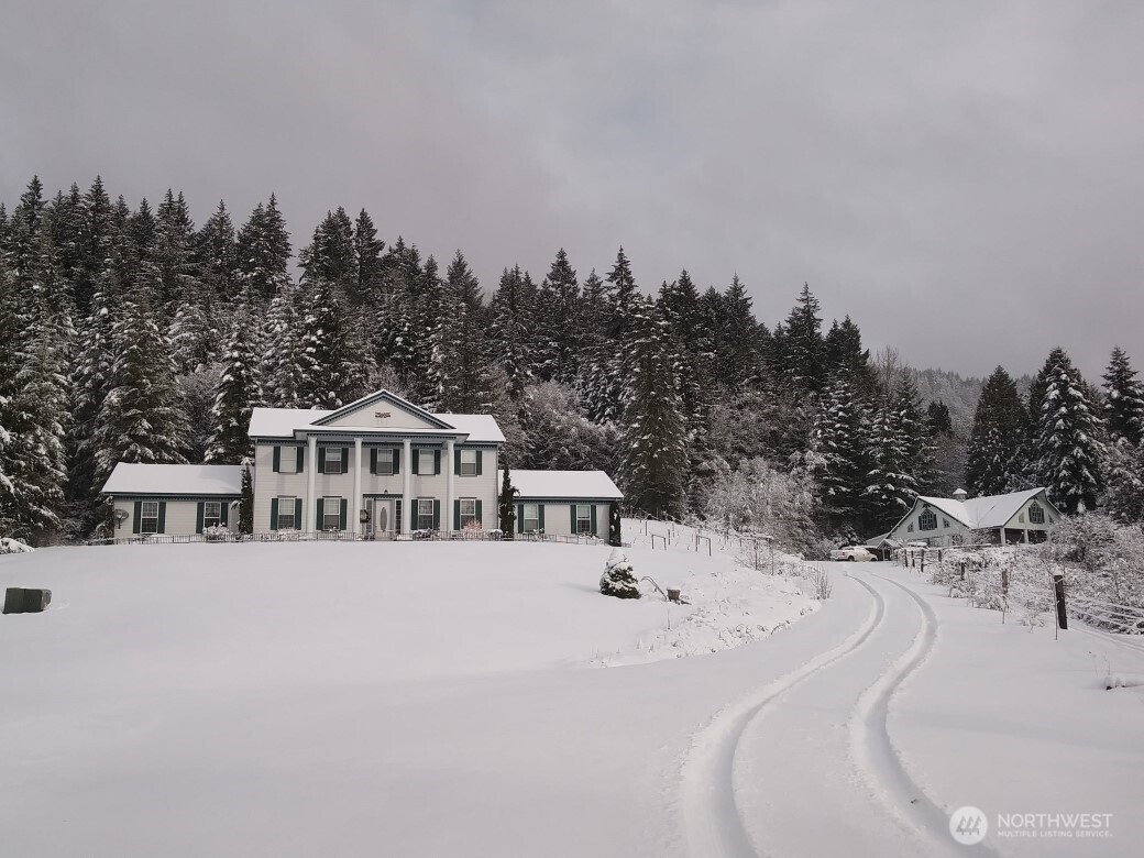 12832 Hunter Road Southwest Rochester, WA 98579 - Photo 3 of 40 a view of a white house with a yard and trees in the background
