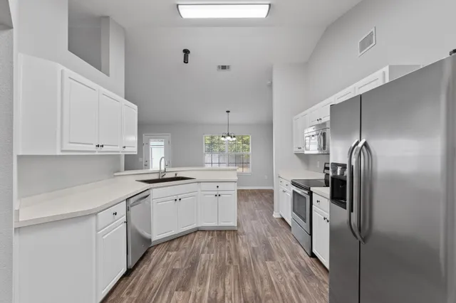 a kitchen with stainless steel appliances a refrigerator stove microwave and sink