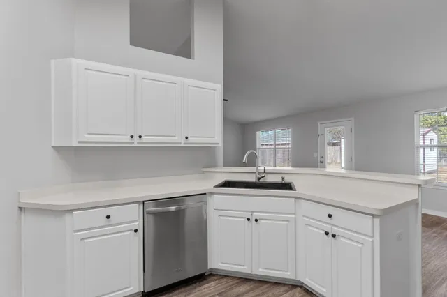 a kitchen with stainless steel appliances white cabinets and a stove a refrigerator with white countertops