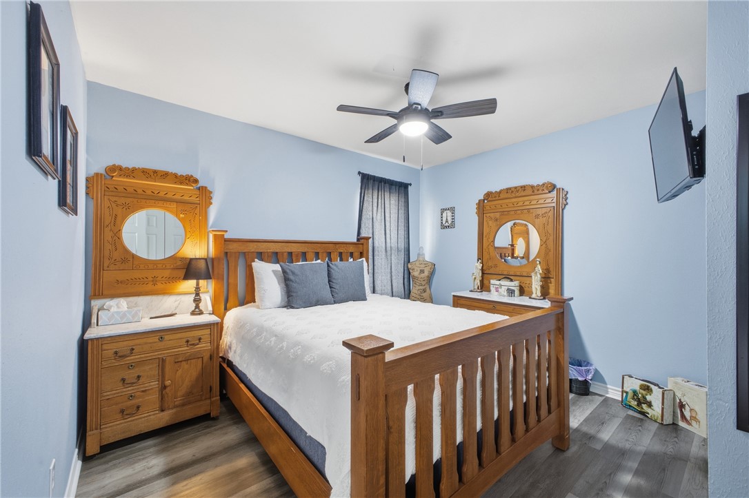 1702 Ibis Court Bryan, TX 77807 - Photo 11 of 18 a bedroom with a bed a dresser and potted plants