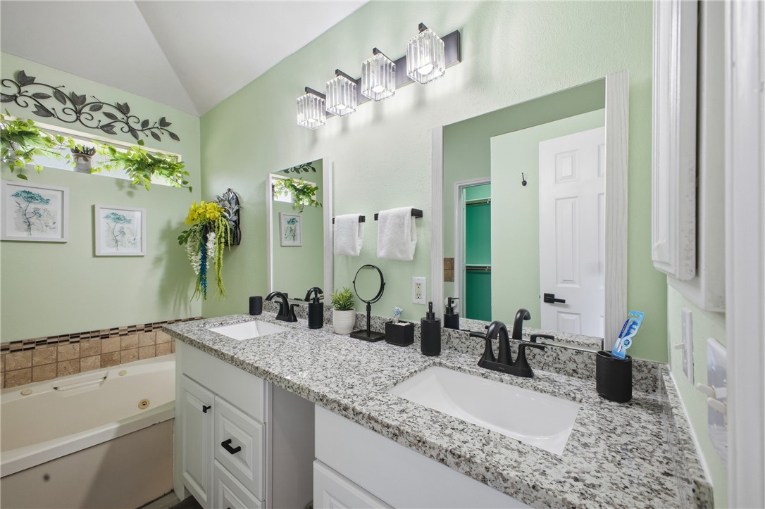 1702 Ibis Court Bryan, TX 77807 - Photo 14 of 18 a bathroom with a granite countertop sink a mirror and a shower