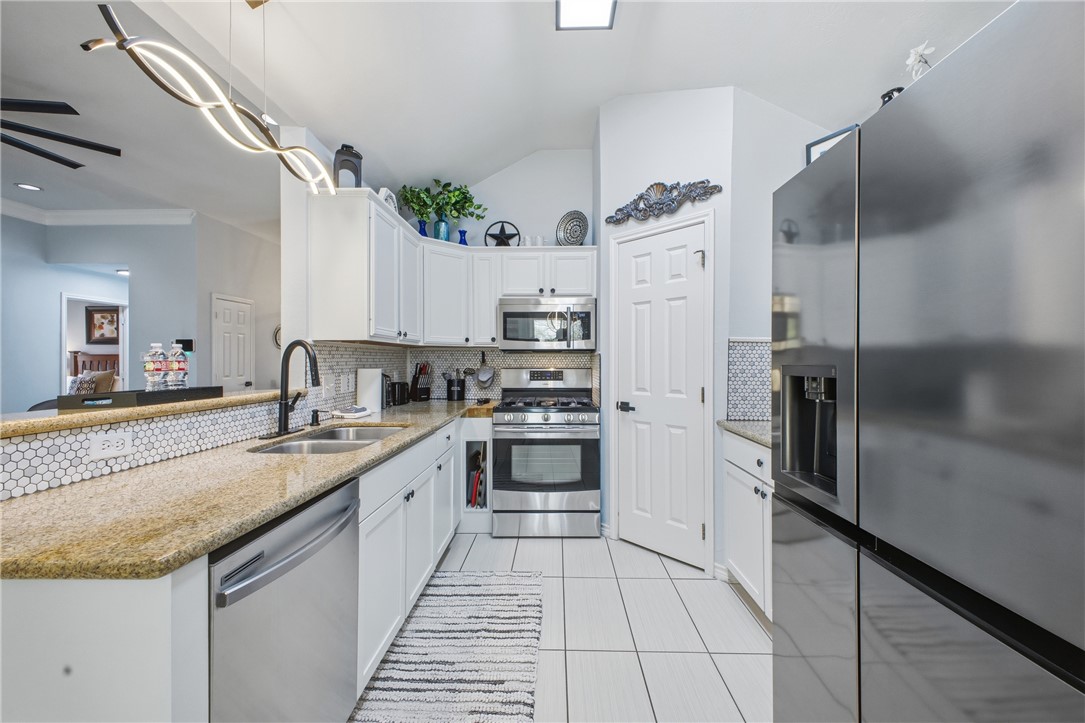 1702 Ibis Court Bryan, TX 77807 - Photo 6 of 18 a large kitchen with granite countertop a sink and stainless steel appliances
