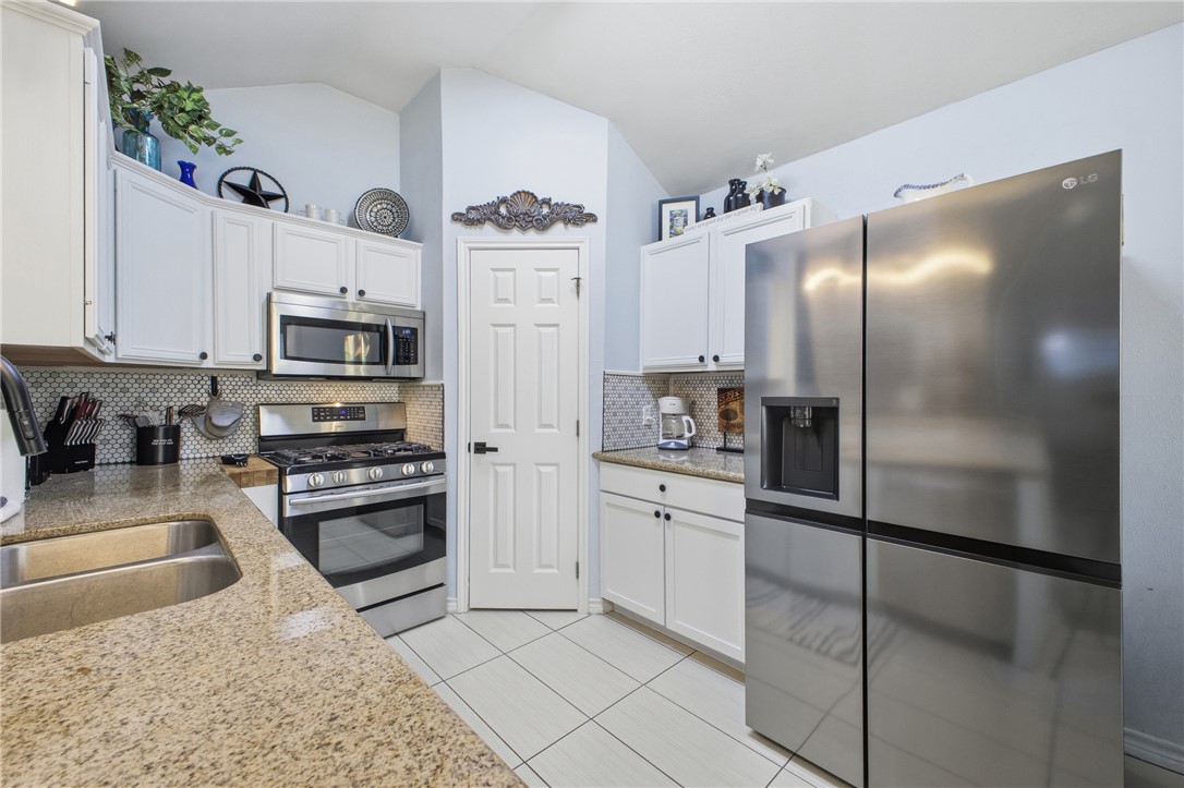 1702 Ibis Court Bryan, TX 77807 - Photo 8 of 18 a kitchen with stainless steel appliances granite countertop a refrigerator a stove and a sink