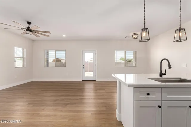 a view of a kitchen with a sink chandelier and wooden floor