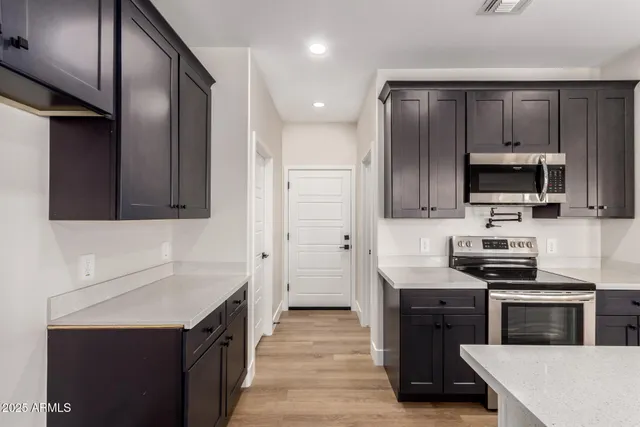a kitchen with stainless steel appliances a sink stove and refrigerator