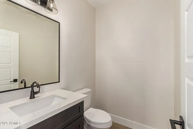 a bathroom with a sink vanity mirror and toilet
