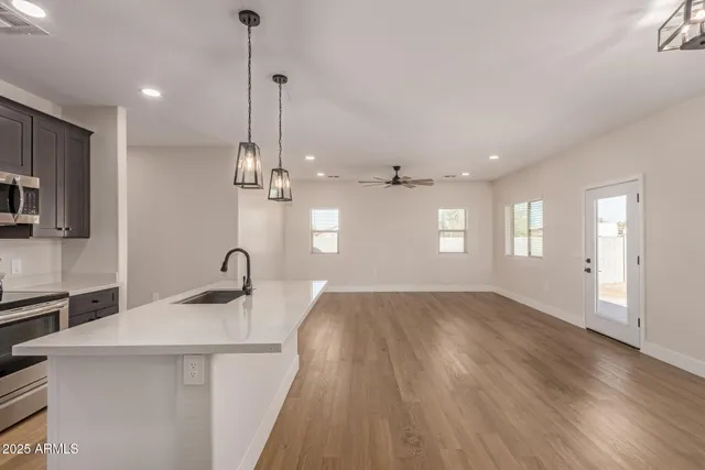 a kitchen with kitchen island a sink stainless steel appliances and cabinets