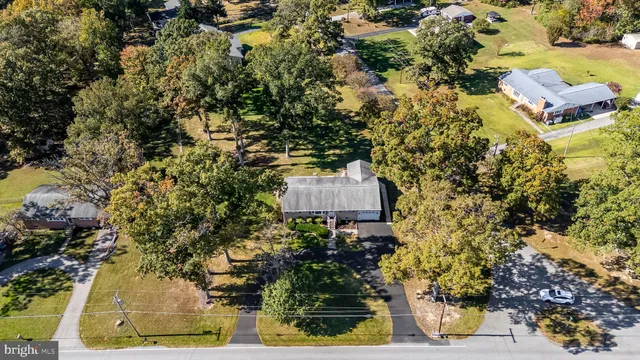 an aerial view of a house with a yard basket ball court and outdoor seating