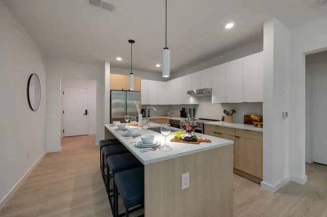 a kitchen with a stove white cabinetry and white appliances