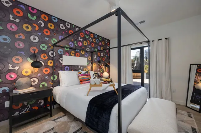 a bedroom with two beds and painting on the wall