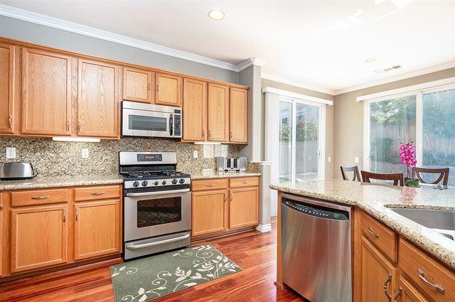 a kitchen with stainless steel appliances granite countertop a sink stove and cabinets