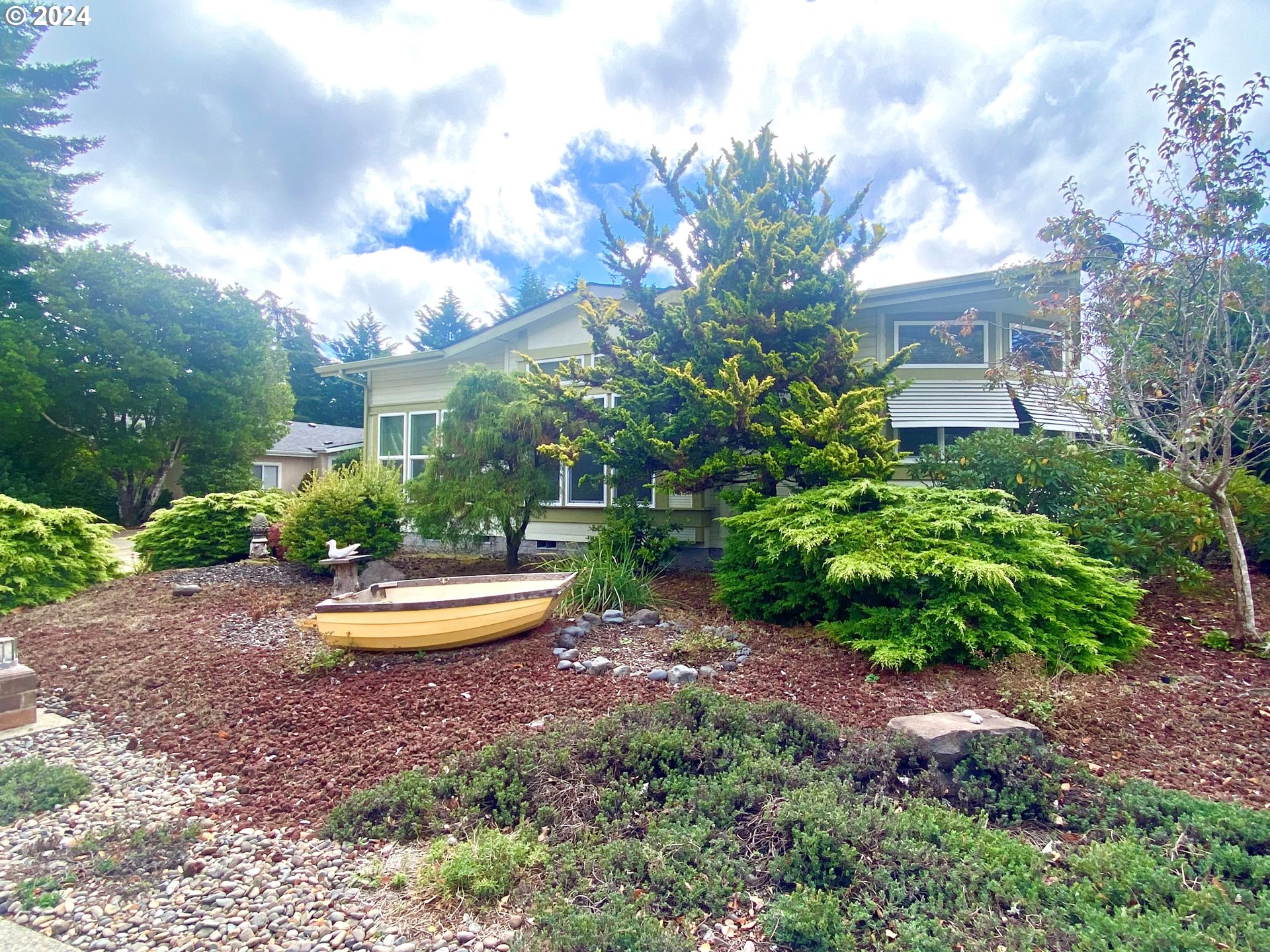 865 Western Way Florence, OR 97439 - Photo 2 of 26 a front view of a house with a yard and fountain