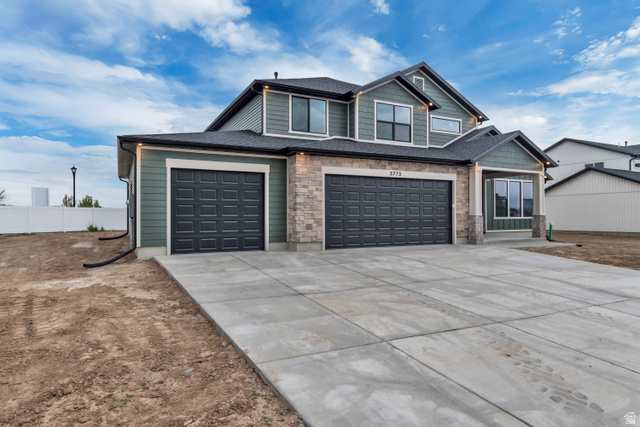 3317 South 1000 West, Unit 6010 Logan, UT 84321 - Photo 3 of 34 Craftsman-style home with driveway, an attached garage, a shingled roof, and stone siding