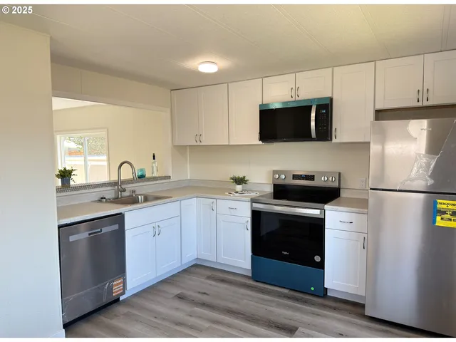 a kitchen with stainless steel appliances granite countertop a stove a sink and a refrigerator