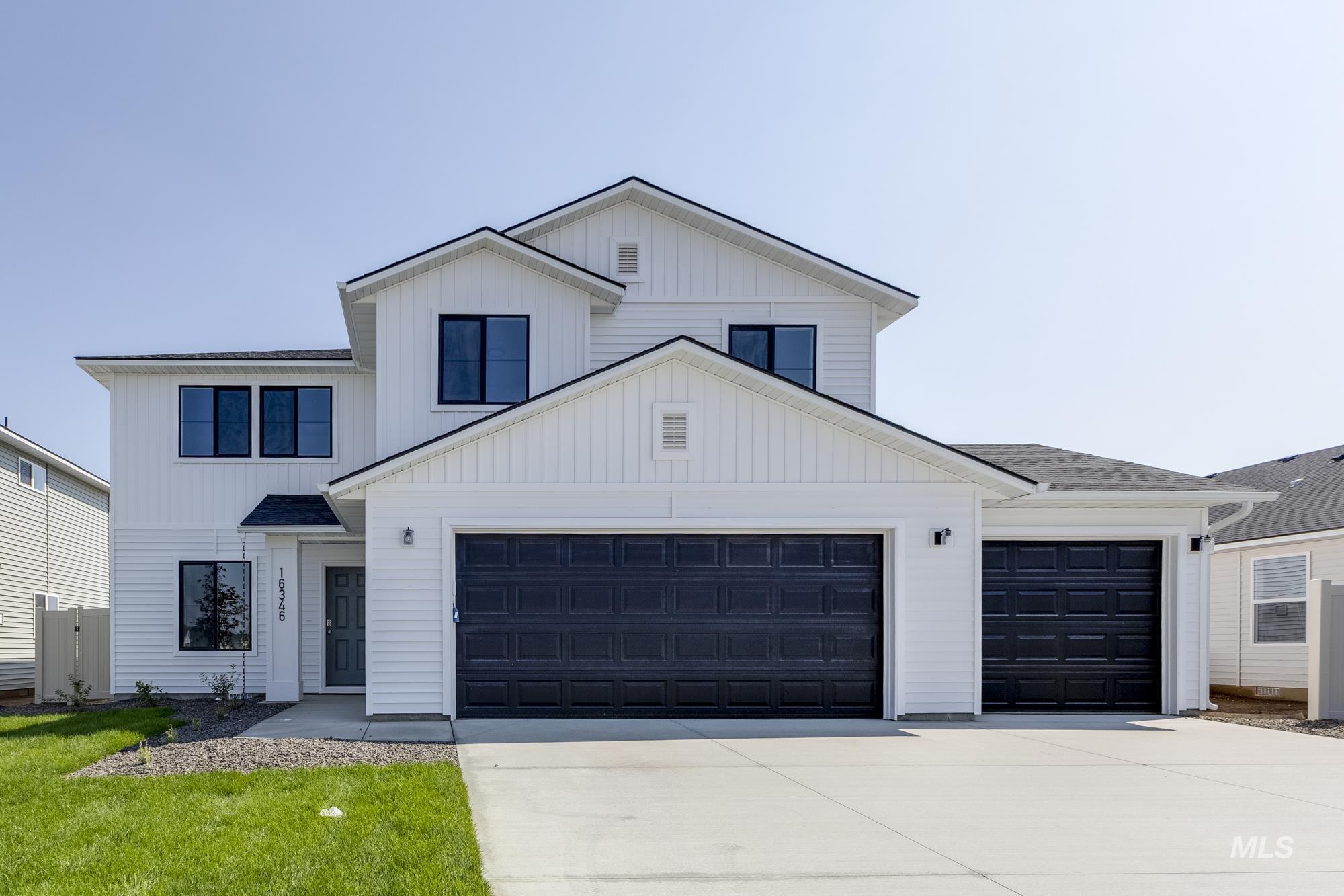 Modern inspired farmhouse with driveway, a garage, board and batten siding, and a shingled roof