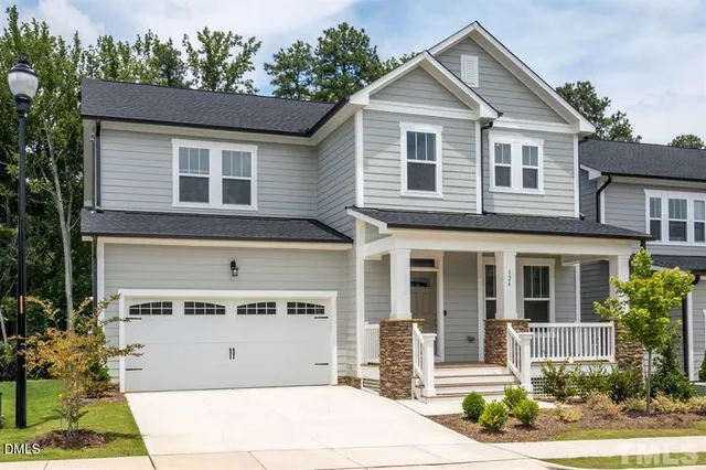 a front view of a house with a yard and potted plants