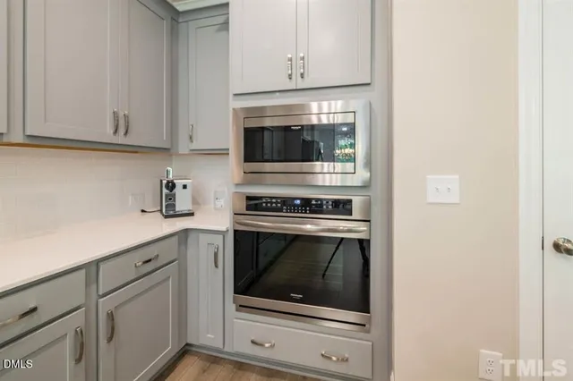 a kitchen with white cabinets and stainless steel appliances
