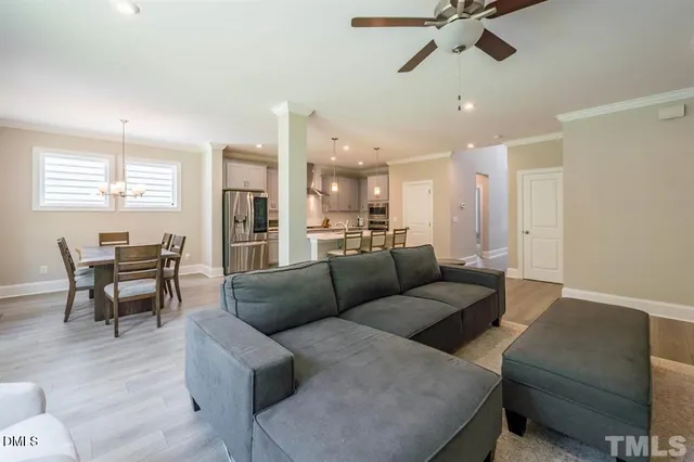 a living room with furniture and a dining table with kitchen view