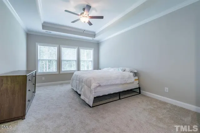 a bed sitting in a spacious bedroom next to a window