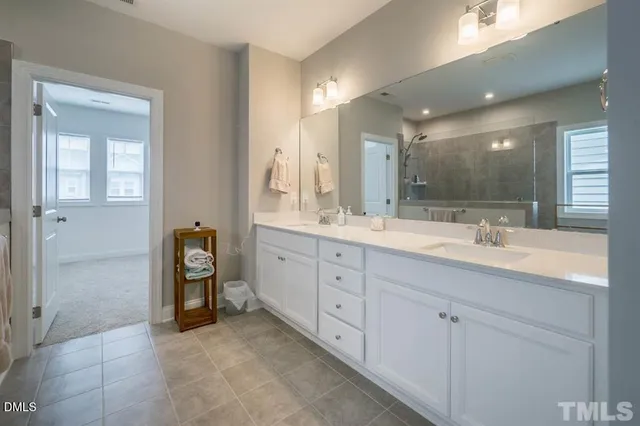 a spacious bathroom with a granite countertop sink mirror and shower