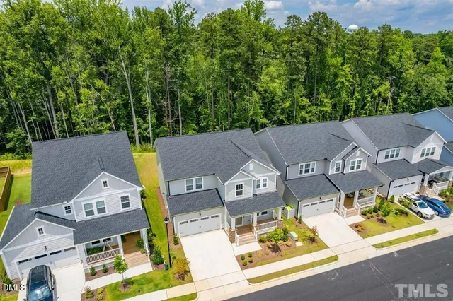 an aerial view of residential house with outdoor space and trees all around
