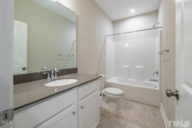 a bathroom with a granite countertop sink toilet mirror and shower