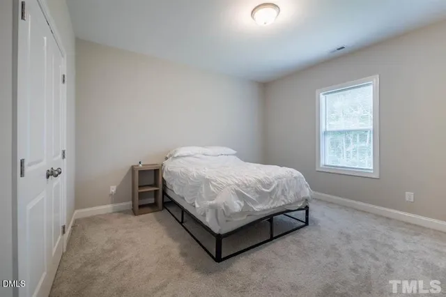 a bed sitting in a bedroom next to a window