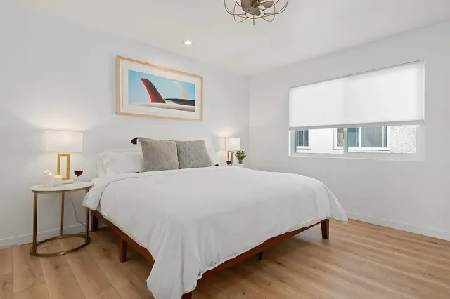 a bedroom with a bed and wooden floor