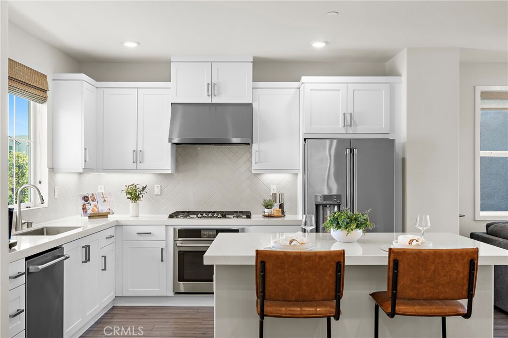 a kitchen with stainless steel appliances a stove a sink refrigerator and cabinets