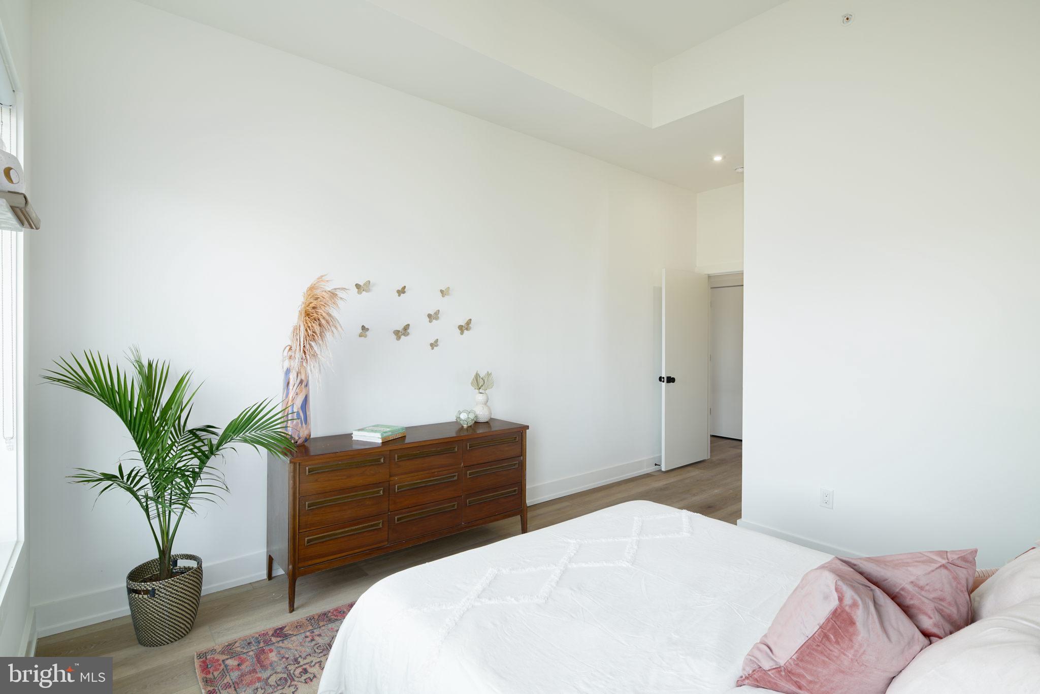 5013 Springfield Avenue, Unit 408 Philadelphia, PA 19143 - Photo 8 of 15 a bedroom with a bed and a potted plant