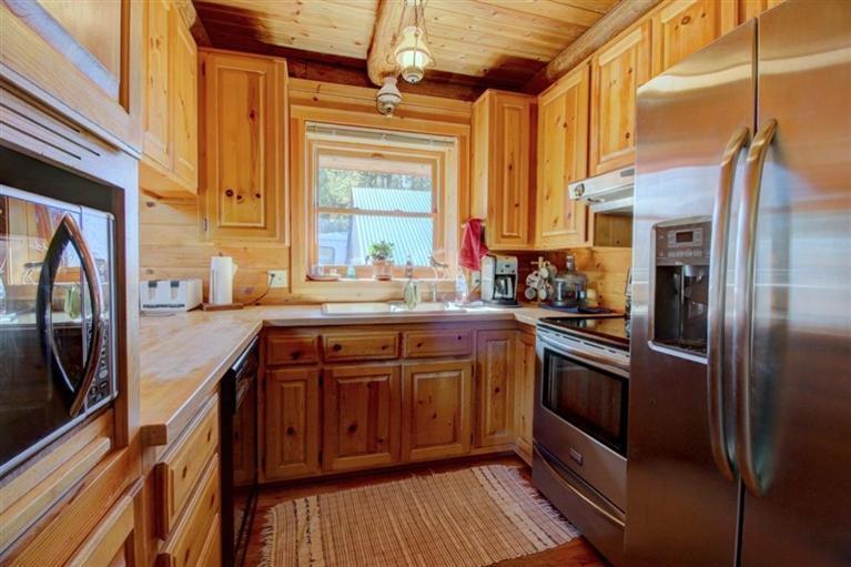 267 Citadel Road Trail, OR 97541 - Photo 7 of 30 a kitchen with stainless steel appliances granite countertop a refrigerator a sink and a stove with wooden floor