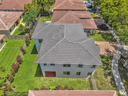an aerial view of a house with yard and green space