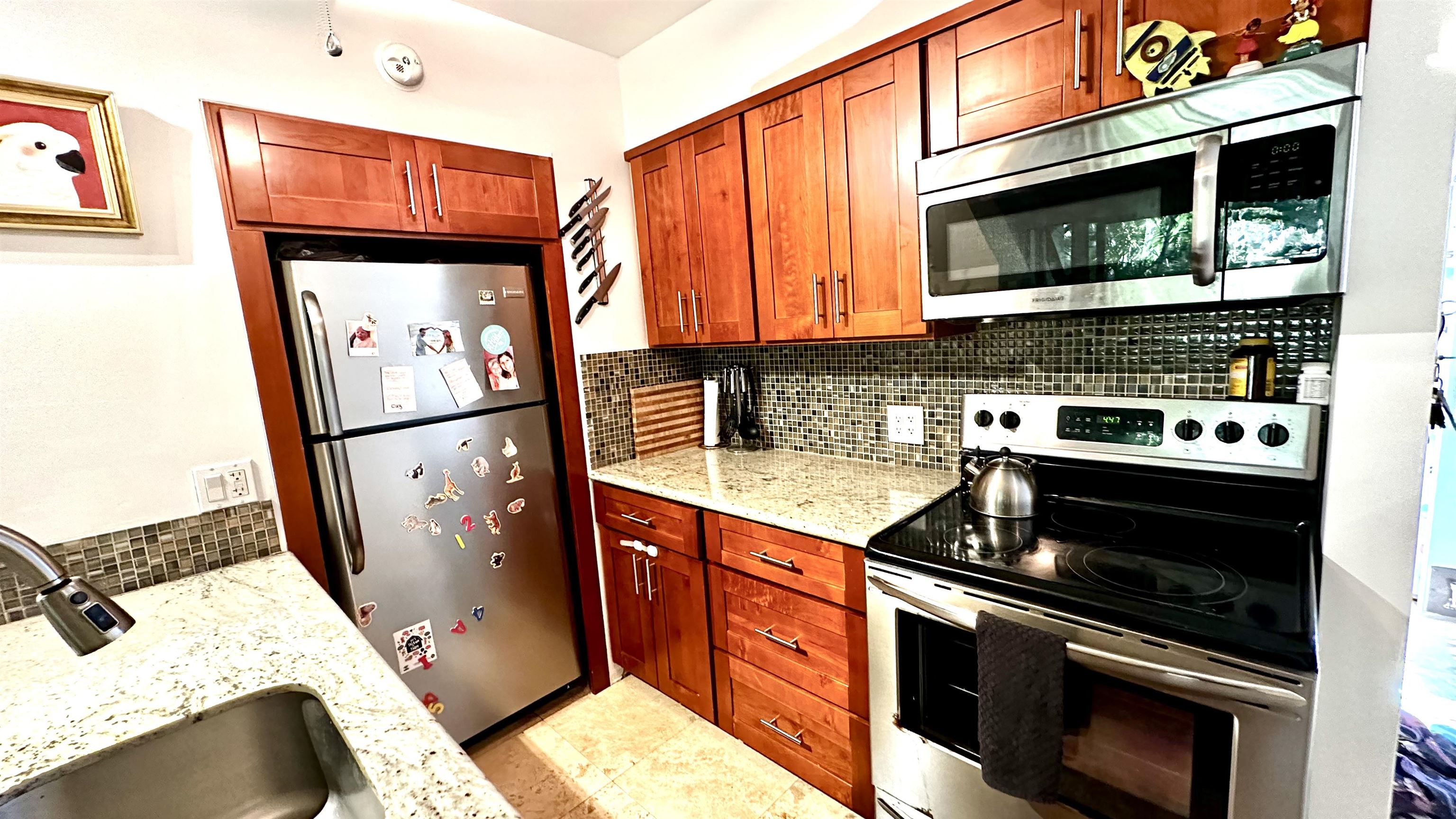 3788 Lower Honoapiilani Road, Unit A208 Lahaina, HI 96761 - Photo 4 of 23 a kitchen with stainless steel appliances granite countertop a stove a sink and a microwave