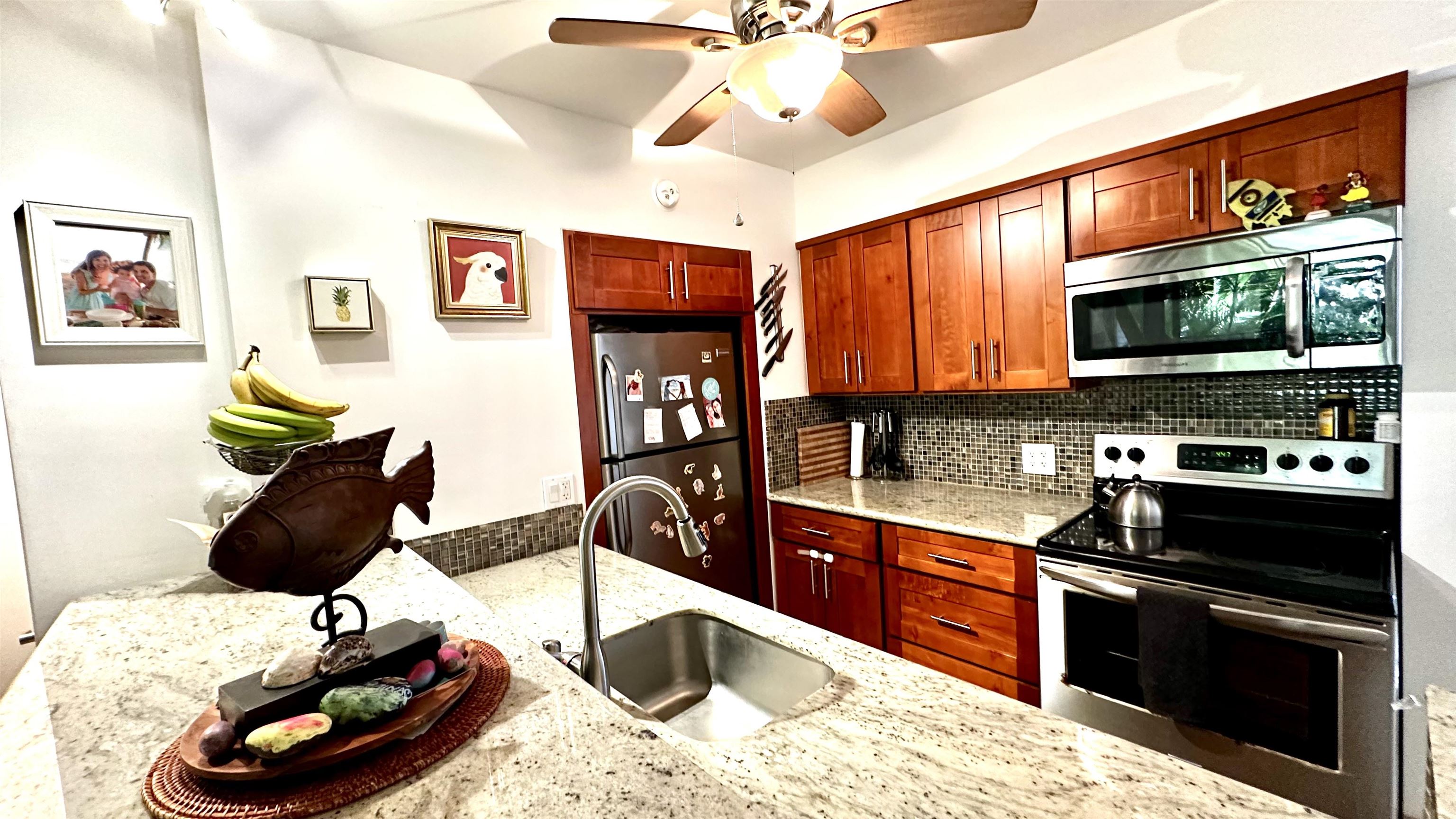 3788 Lower Honoapiilani Road, Unit A208 Lahaina, HI 96761 - Photo 5 of 23 a kitchen with stainless steel appliances kitchen island granite countertop a sink and cabinets
