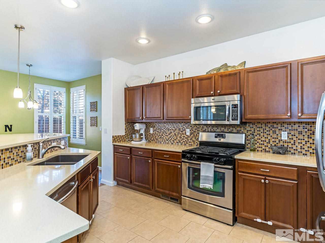855 Caughlin Crossing Reno, NV 89519 - Photo 13 of 25 a kitchen with stainless steel appliances granite countertop a stove a sink and a microwave