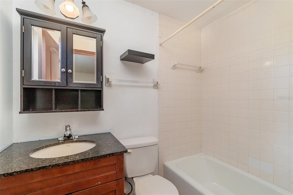 2729 Broadway Fort Myers, FL 33901 - Photo 35 of 49 a bathroom with a granite countertop sink toilet a mirror and shower