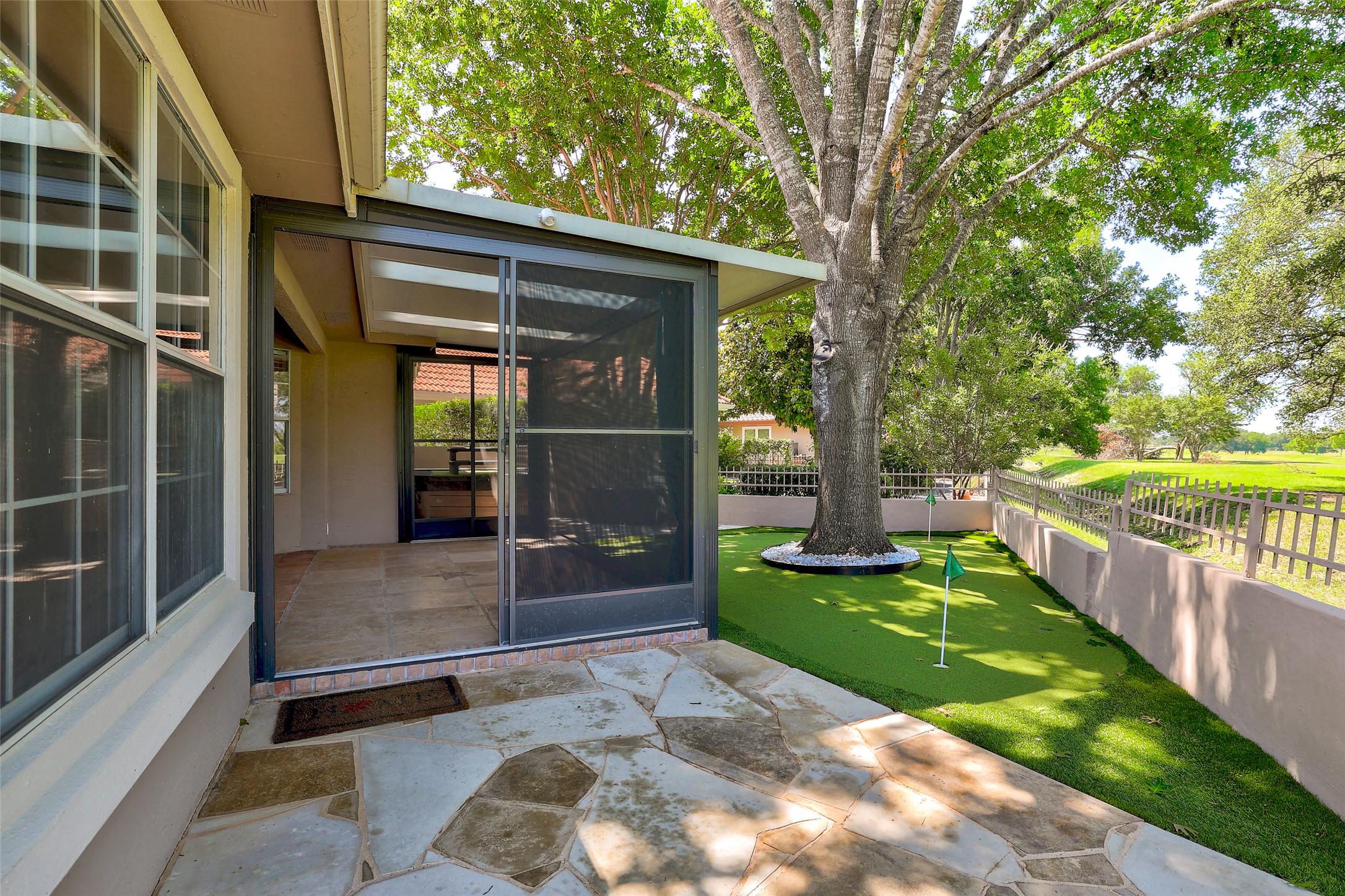 30107 Hamlet Circle Georgetown, TX 78628 - Photo 28 of 40 Enjoy outdoor leisure with a screened porch, flagstone patio, and a private putting green under mature trees.
