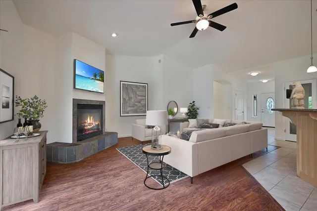 a living room with furniture a fireplace and a ceiling fan