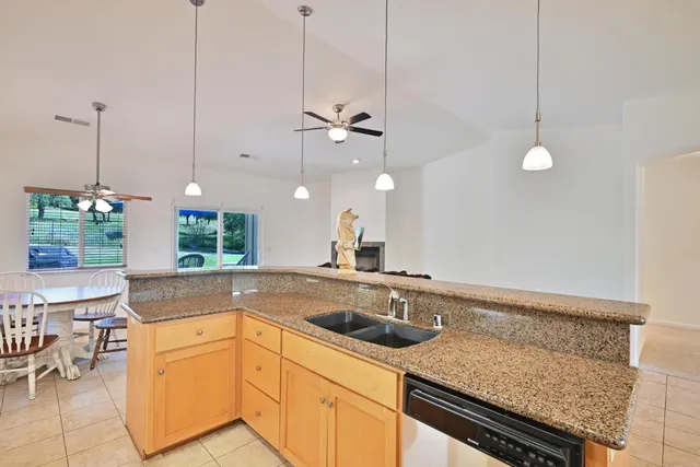 a kitchen with a sink a stove and chairs