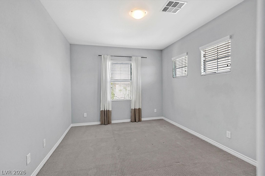 1106 Langston Ranch Avenue Henderson, NV 89002 - Photo 23 of 36 A well-lit bedroom features plush carpeting and multiple windows for abundant natural light.