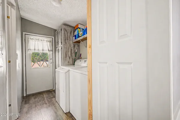 a view of hallway with wooden floor and a window