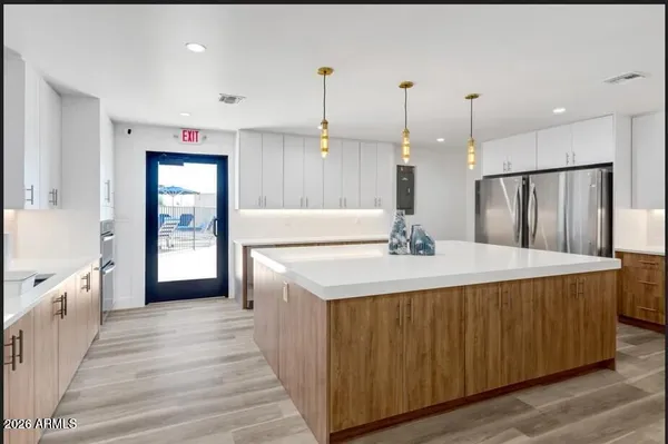 a large kitchen with kitchen island a stove a sink a center island and wooden floor