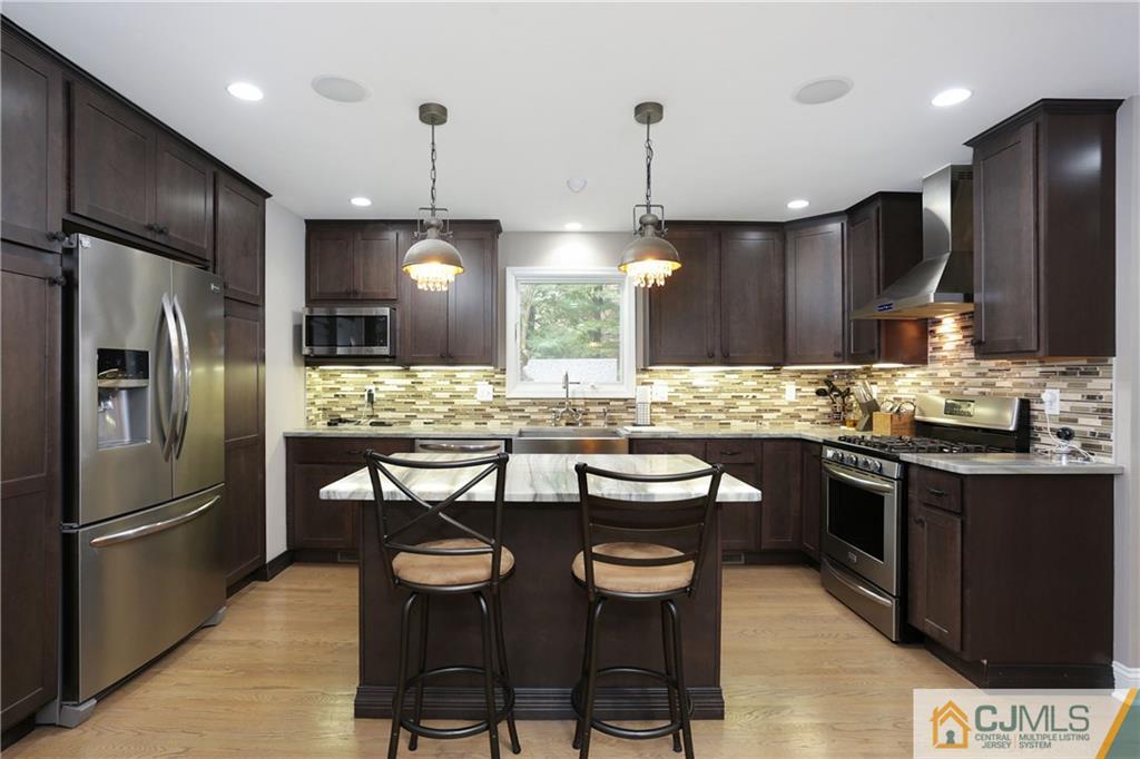 556 Ridge Road Monmouth Junction, NJ 08852 - Photo 3 of 19 a kitchen with stainless steel appliances kitchen island granite countertop a sink a stove a refrigerator and chairs