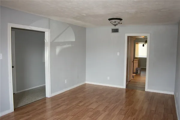 a view of a hallway with wooden floor and closet