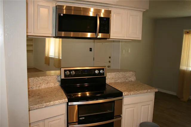 a kitchen with wooden cabinets and a stove top oven